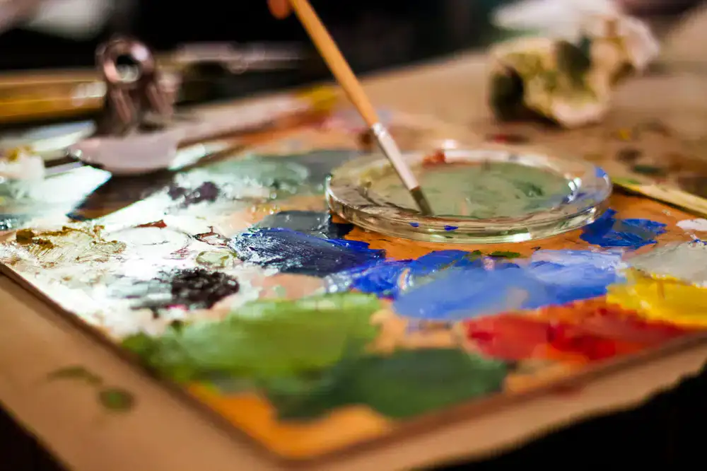 Close up of a painter mixing acrylic colors on a wet palette